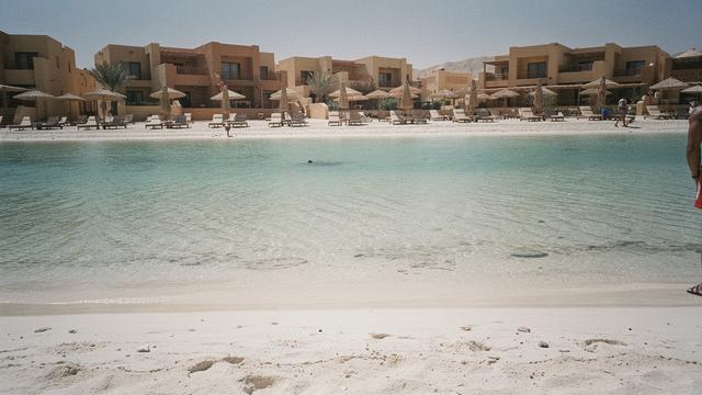 Shallow turquoise lagoon beside a family resort beach at midday